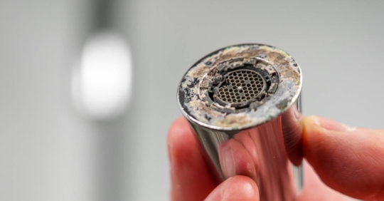 faucet aerator that has become clogged with mineral deposits and grime.