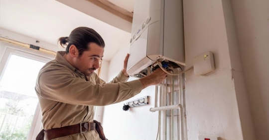 Repairman on a house call fixing a gas boiler